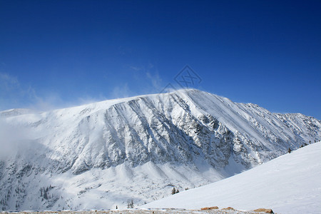 科罗拉多滑雪雪覆盖山蓝天滑雪背包踪迹岩石登山单板高度首脑雪崩背景