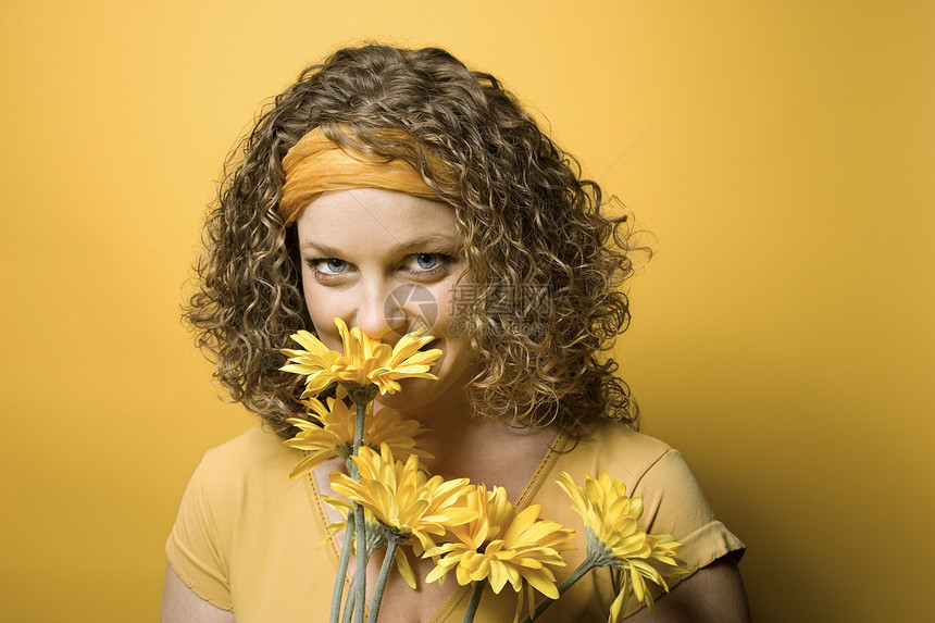 女人闻到花香花束眼神卷发照片女性黄色头巾雏菊水平微笑图片