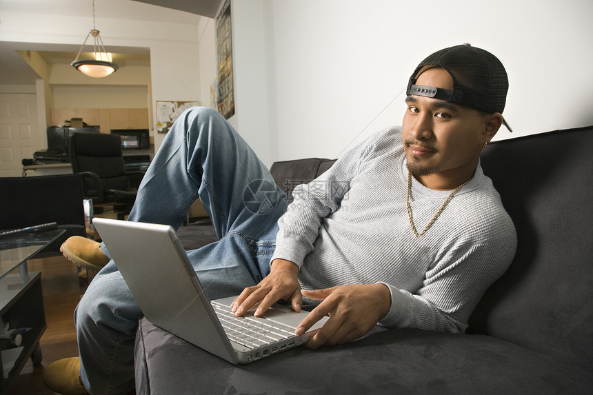 男人在笔记本电脑上打字沙发技术房子观众照片眼神成人互联网上网图片