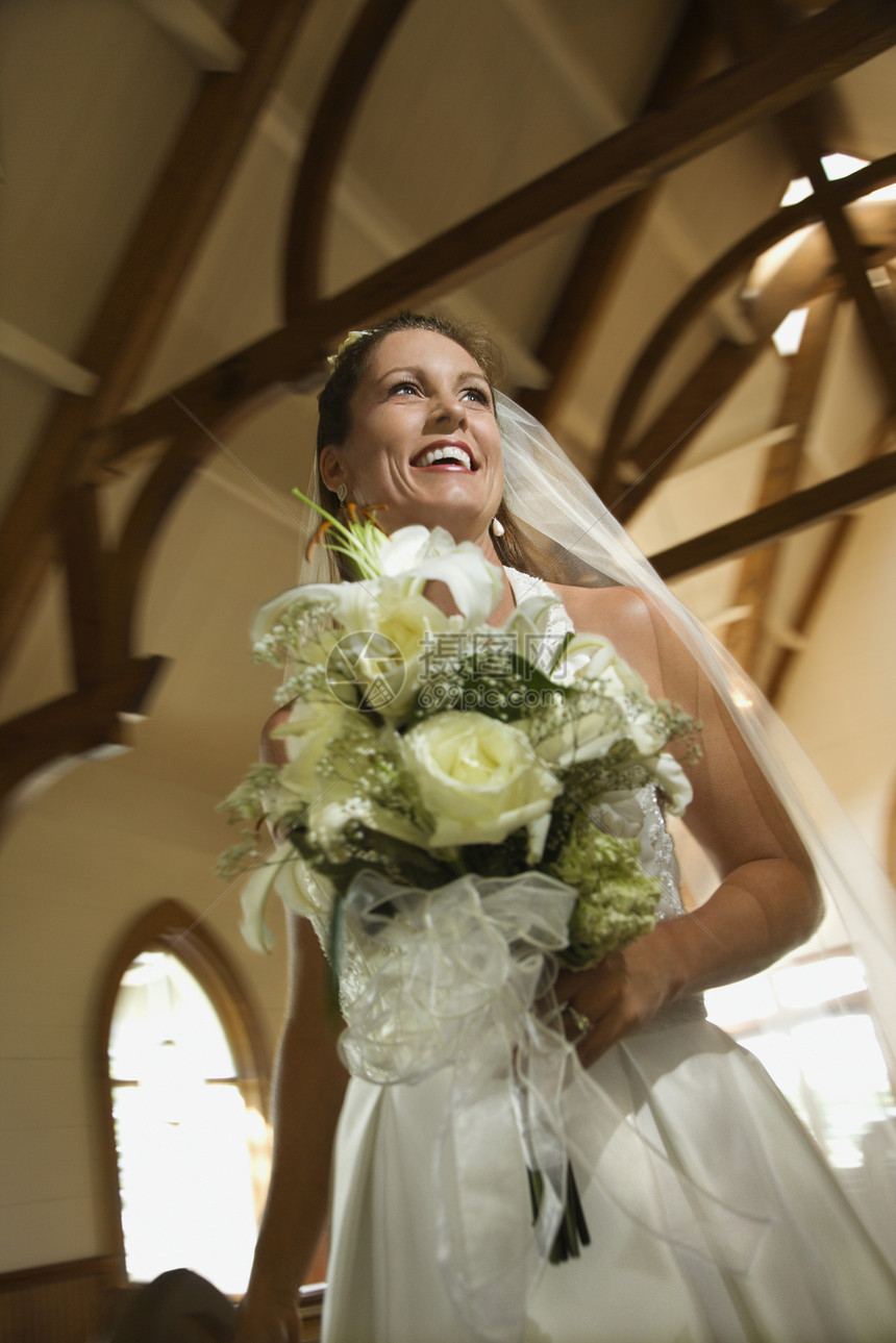 新娘拿着花束婚礼妻子微笑婚姻女士教会花朵照片低角度婚纱图片