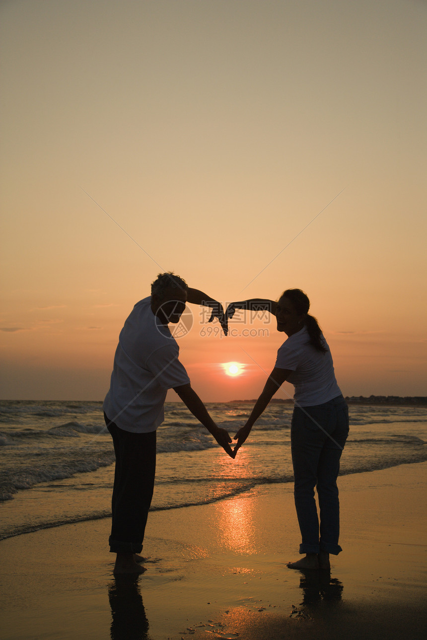 浪漫情侣男人中年人丈夫中年支撑日落配偶两个人假期海滩图片