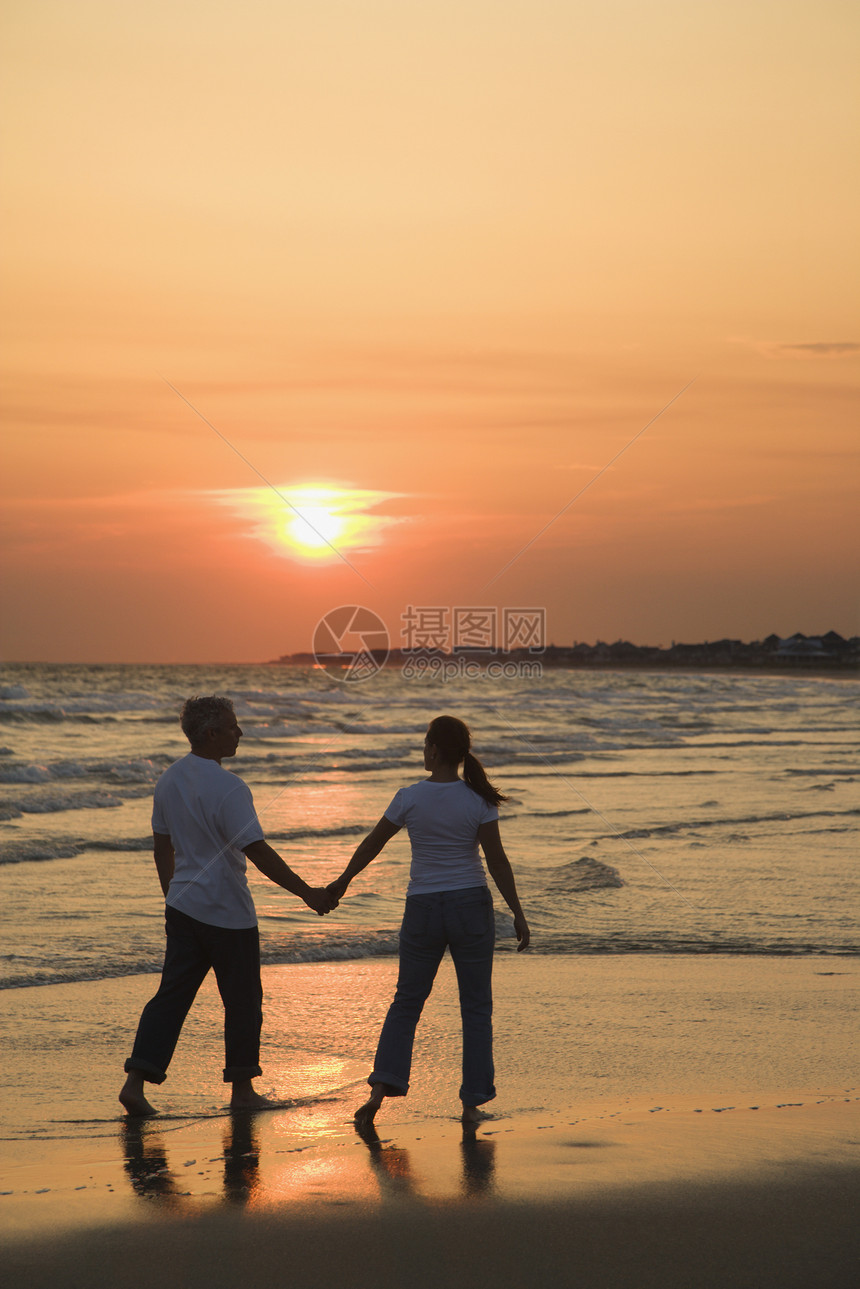 海滩上的一些夫妇丈夫中年人海岸配偶中年日落妻子女士闲暇海浪图片