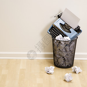 垃圾桶里的打字机背景图片