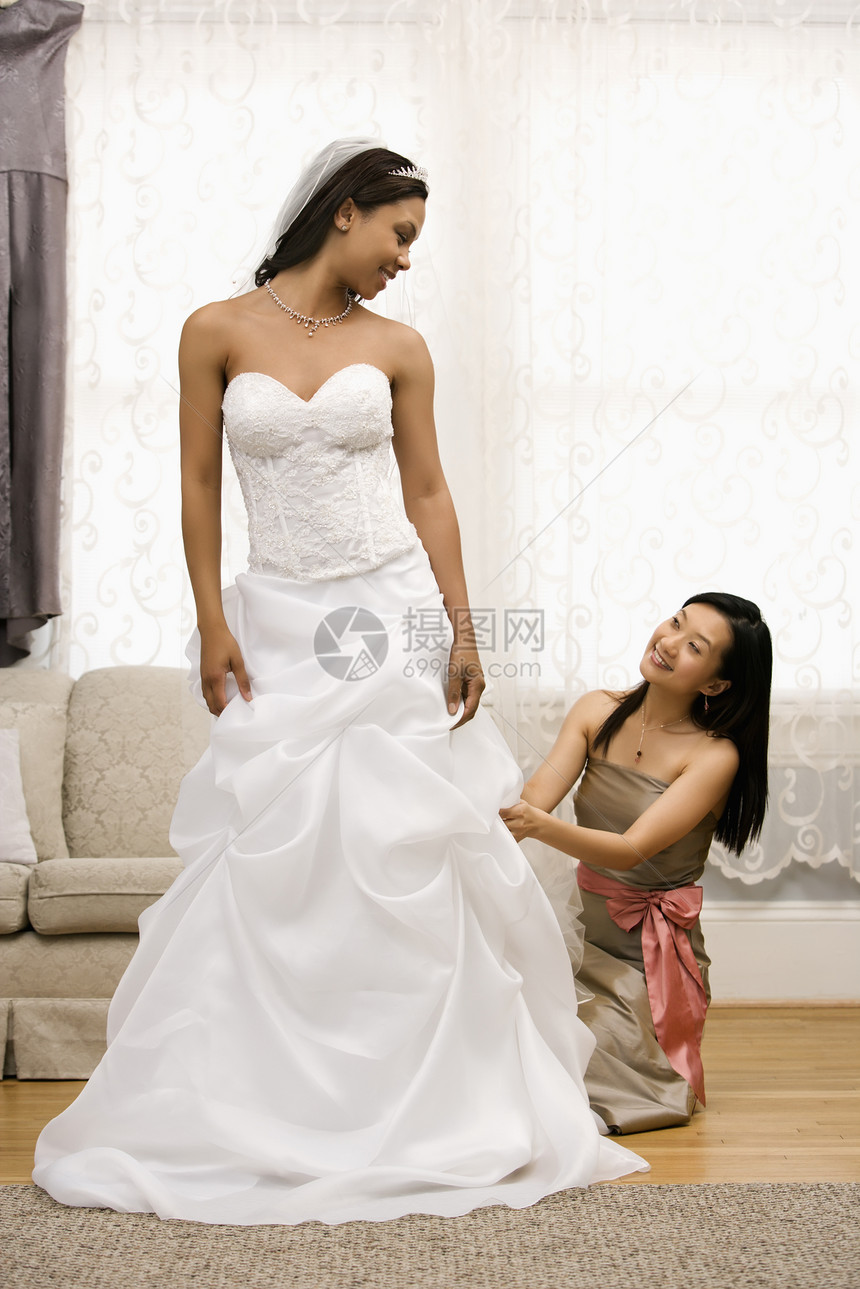 新娘调整新娘的礼服图片