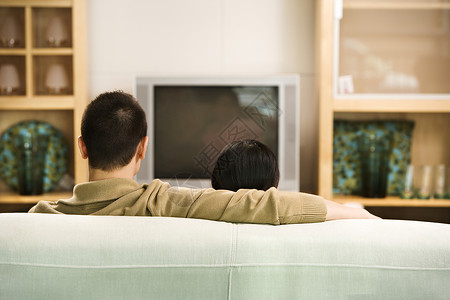 夫妇看电视女朋友闲暇男性女士娱乐男人电视家庭场景客厅背景图片