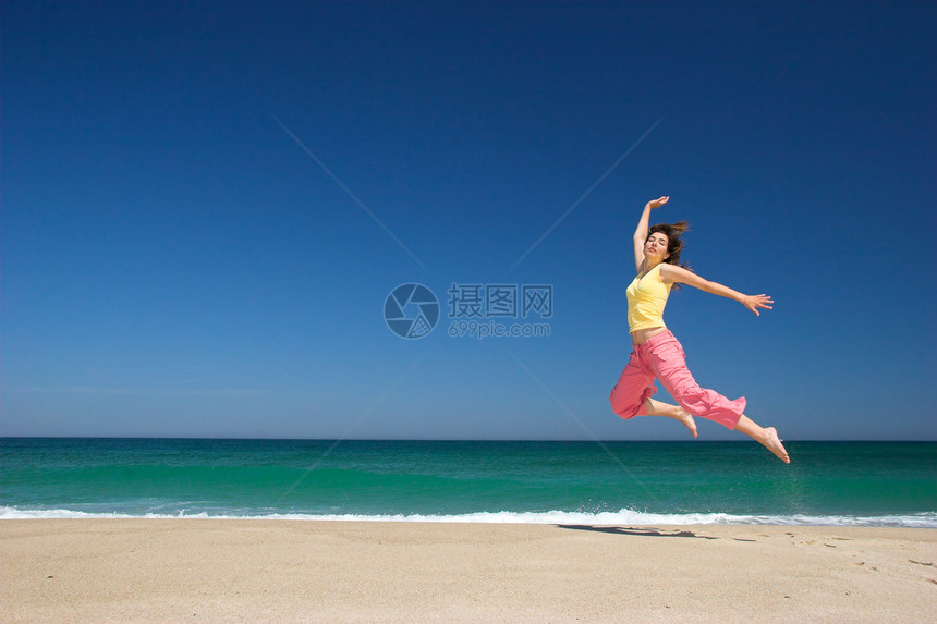 美丽的女人在海滩上跳跃运动热带自由灵魂女孩蓝色身体女性女士阳光图片