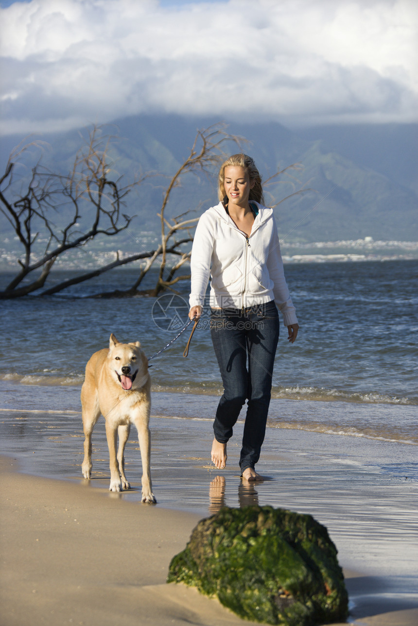 女人走路狗活动金发女郎闲暇遛狗海岸动物犬类宠物金发海滩图片