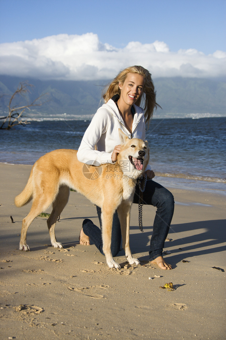 带着狗的女人娱乐棕色活动海岸海滩宠物犬类成人闲暇遛狗图片
