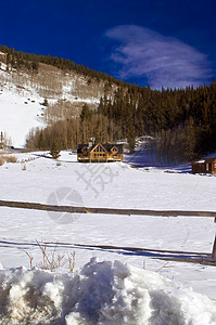 科罗拉多州雪中的日志棚屋背景图片