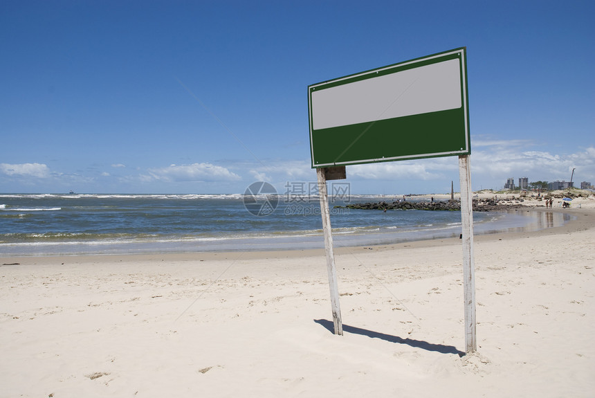 在海滩上签字晴天风景白色蓝天绿色警告海岸线阳光图片