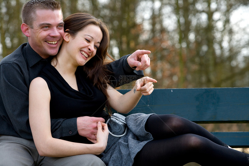 坐在长椅上玩得开心的年轻夫妇图片