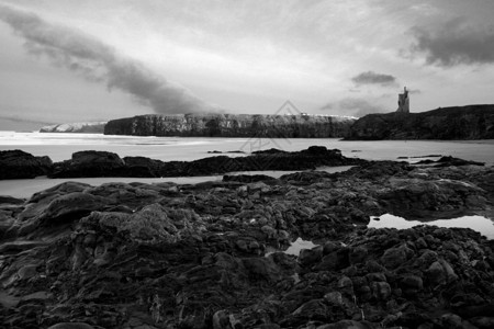 黑黑岩石悬崖天空风暴蓝色支撑海岸水池石头海岸线海滩背景图片