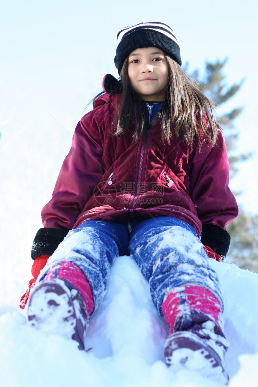 坐在雪山上的CHild夹克乐趣锻炼女孩晴天空气孩子手套爬坡道帽子图片