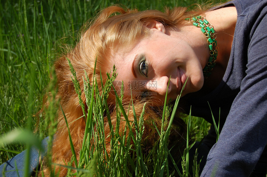 躺在绿草中场地休息女孩头发红色女性晴天女士绿色太阳图片
