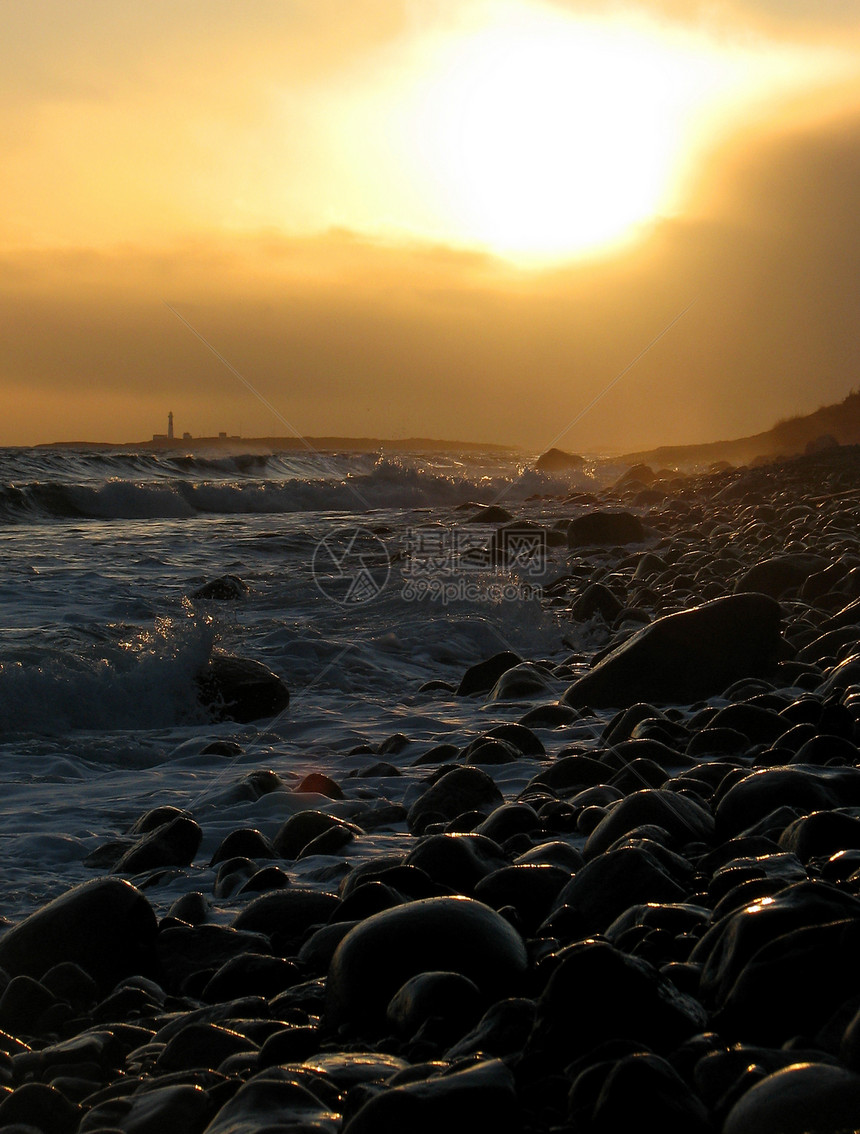日落时灯塔海滩海浪支撑风暴图片