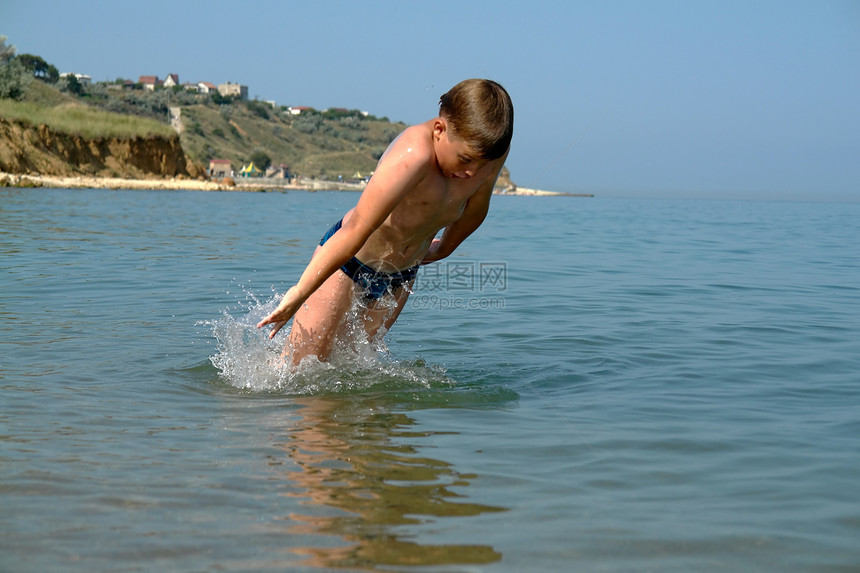 男孩跳进波浪阳光生活太阳飞溅跑步孩子们孩子冲浪旅行儿子图片