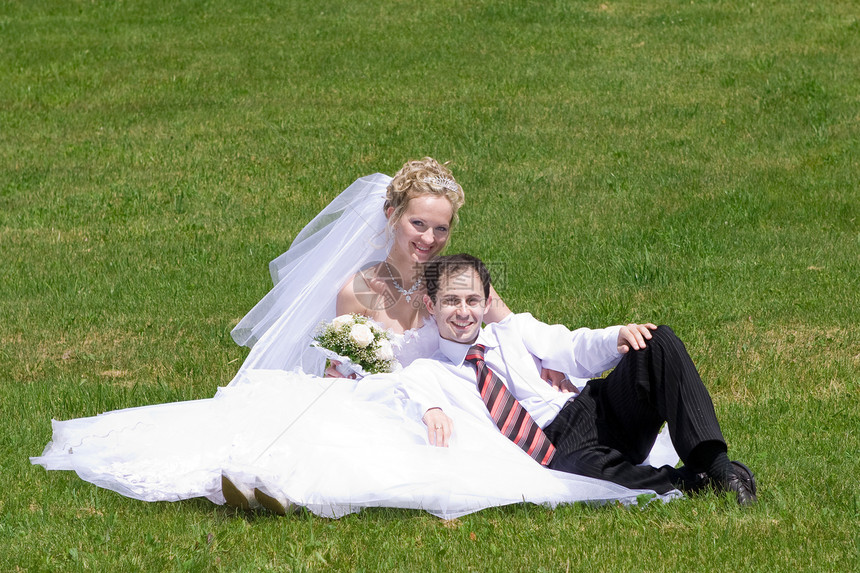 在草地上新婚夫妇的其余配偶图片