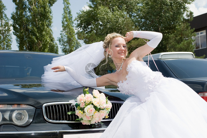 一个快乐的新娘 由一辆车图片