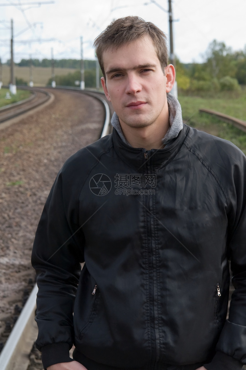 男人在铁轨上头发铁路眼睛沉思成人牛仔裤白色衣服图片