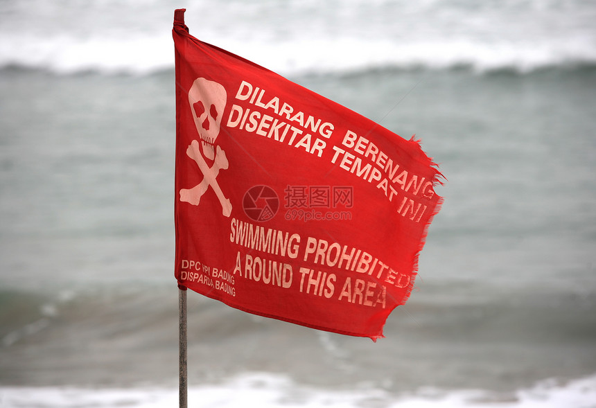游泳禁止了这一地区的一圈旗帜红色蓝色颅骨海岸棕色海滩冲浪支撑游客图片