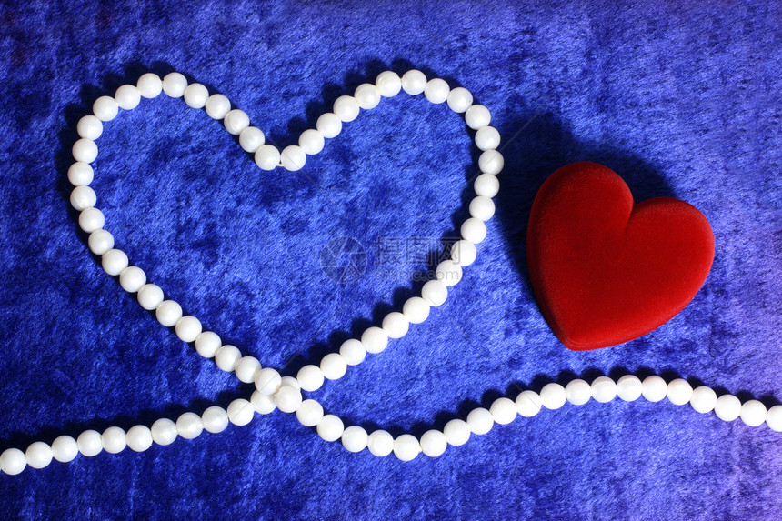 红色的红心和蓝色天鹅绒上的珍珠花束奢华项链细绳宝石白色珠宝图片