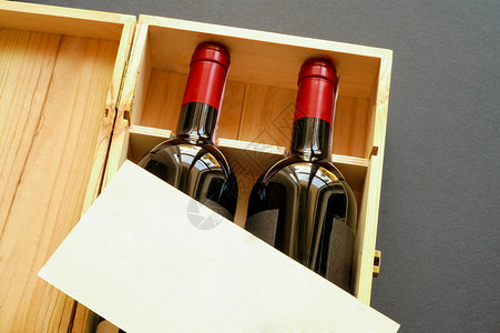带标签素材配有两个葡萄酒瓶和空白卡(横向)的木制礼品盒背景