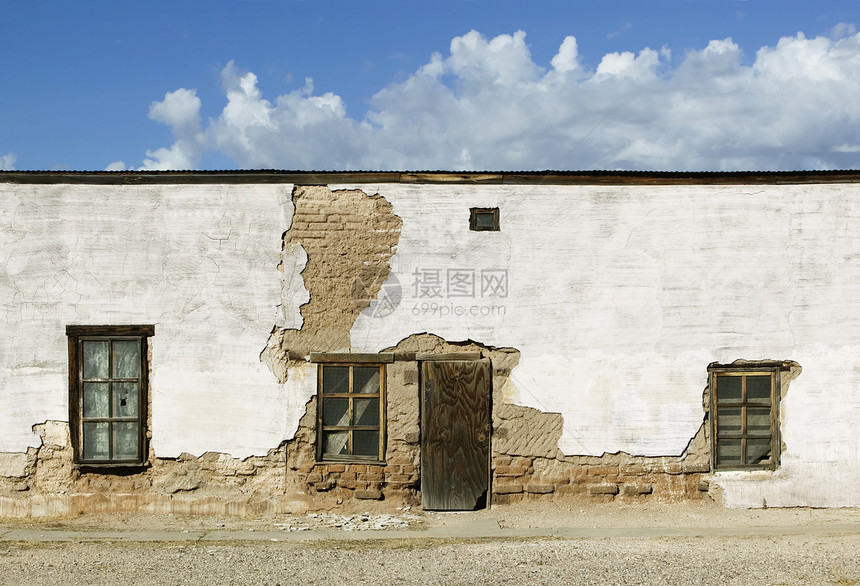 被遗弃的Adobe大楼窗户木板卷云石膏土坯天空建筑建造沙漠人行道图片