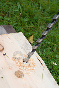 在木材中钻探手钻作坊金工工具钻头螺旋线缠绕穿孔金属木头背景图片