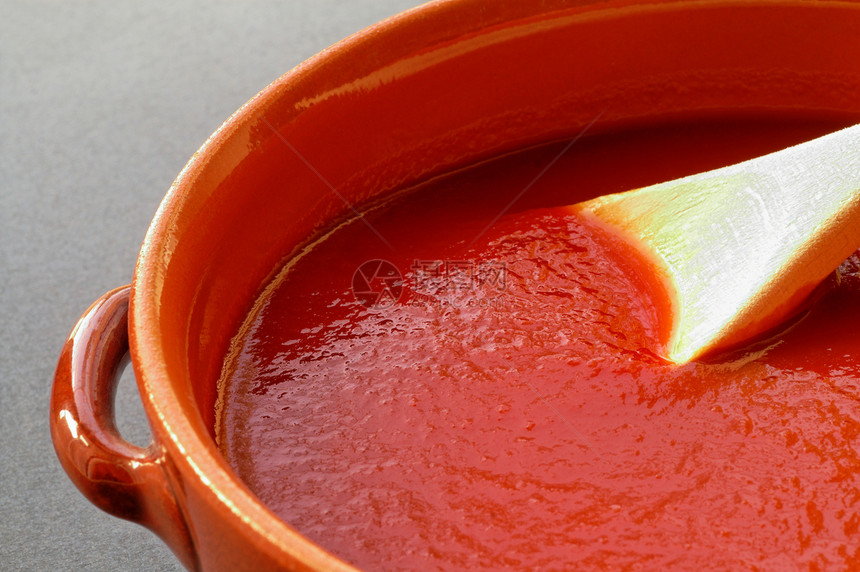 Terracotta锅和配番茄酱的木勺子图片
