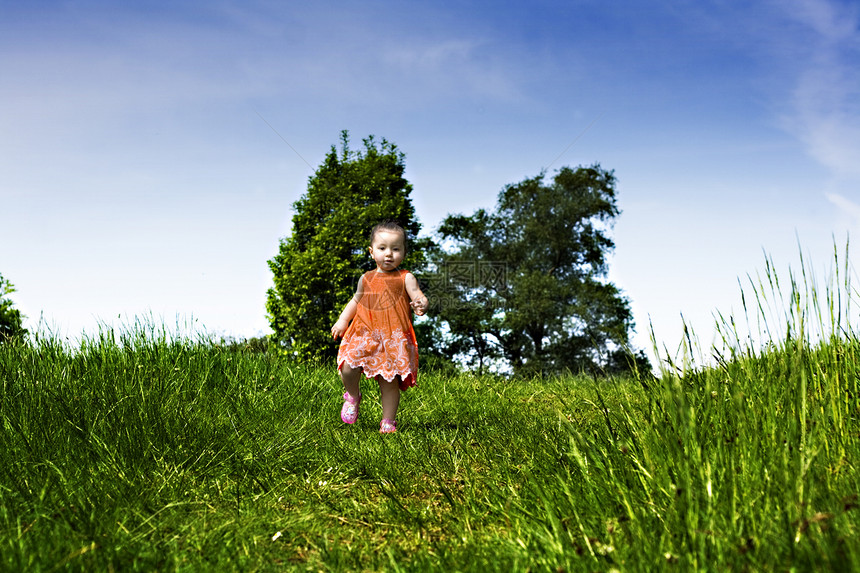 女婴在公园里跑过女孩孩子橙子天空裙子童年女性儿童孩子们头发图片