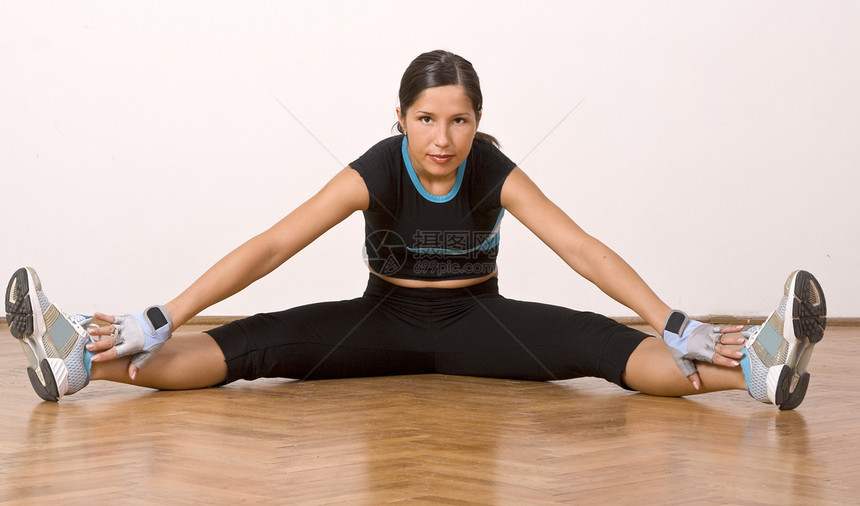 伸展运动黑发女性化蓝色地面体操女性女士培训师木地板训练图片