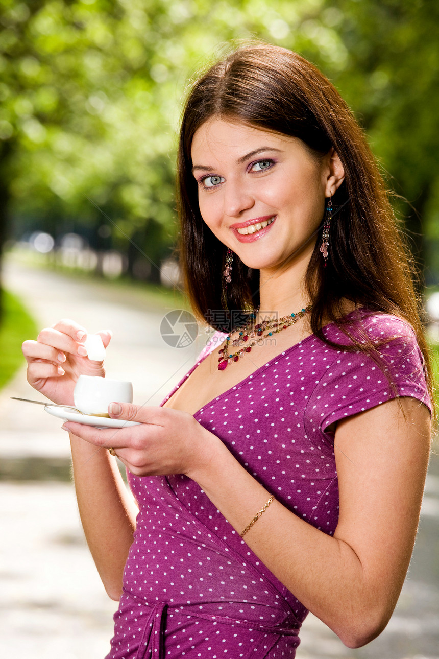 美丽的年轻女子和咖啡逗乐裙子微笑乐趣杯子黑发城市飞碟幸福女士图片