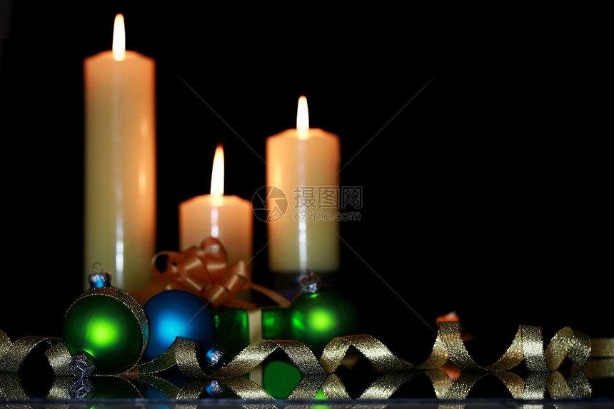 三个烧着的蜡烛和圣诞装饰品图片