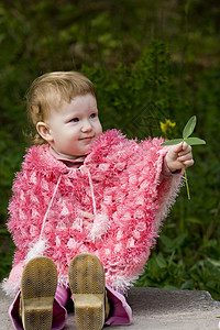 可爱儿童公园宝贝孩子石头叶子粉色雨披绿色背景图片