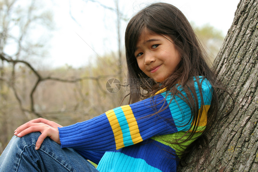 坐在树上可爱的小女孩福利微笑倾斜精力孩子牛仔裤混血女性图片