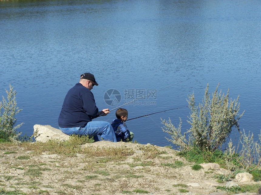 父亲和儿子在湖边捕鱼图片