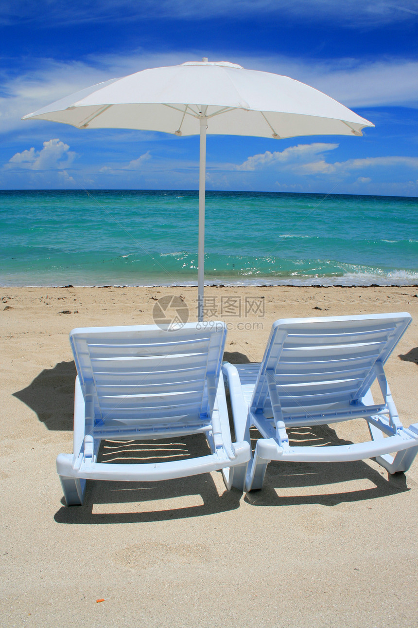 沙滩伞和休息室椅地平线蓝色晴天支撑太阳木头码头海浪海岸线海洋图片