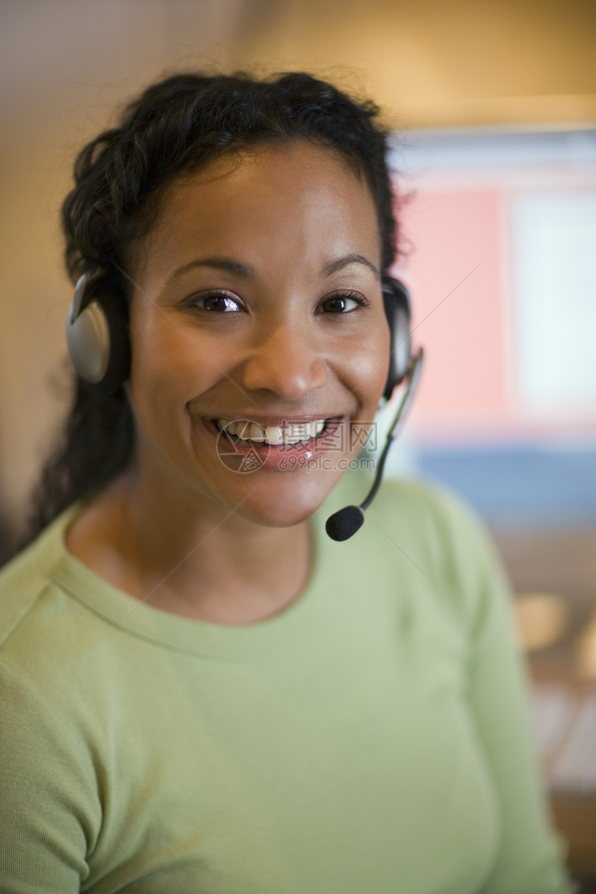 带着耳盔的漂亮年轻女子麦克风电脑呼唤商业幸福眼神沟通微笑成人工人图片
