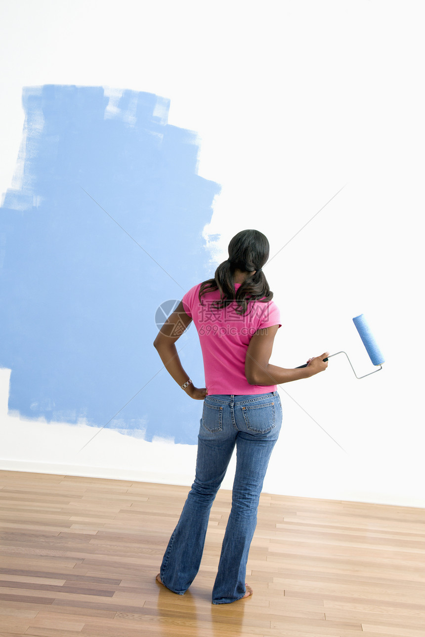 妇女观察油漆工作审查女性照片女士蓝色滚筒绘画图片