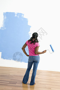 妇女观察油漆工作审查女性照片女士蓝色滚筒绘画背景图片