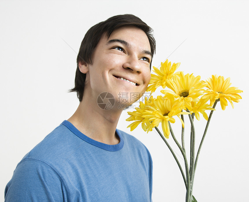 男人拿着花束表情微笑工作室水平男性黑发黄色植物照片图片