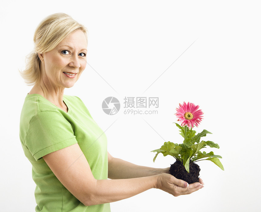 微笑的女人拿着发蜂菊女性成人白色金发女郎观众女士生活生长中年植物图片