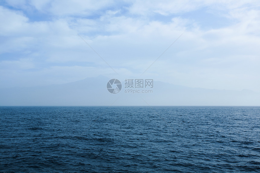 远山山脉天空海浪起伏蓝色海洋图片