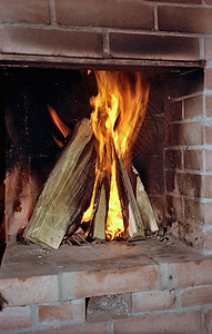 在壁炉中烧柴木头火焰乡村房子加热点燃村庄红色背景