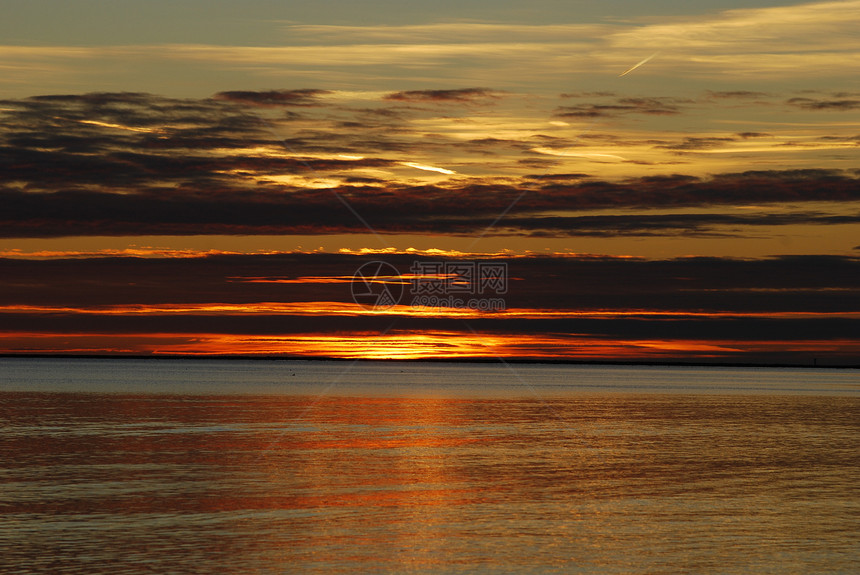 日落在沙滩上橙子海滩黑色天空太阳蓝色海浪图片