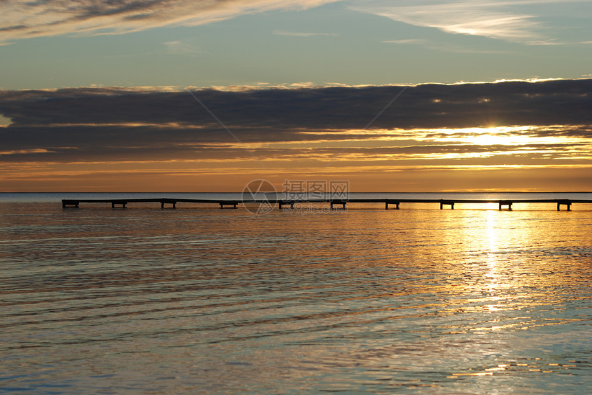 日落在法尔斯特博海滩上黑色蓝色天空太阳海浪橙子海滩图片