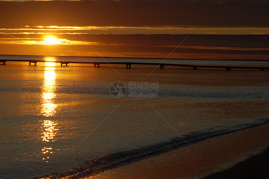 日落在法尔斯特博海滩上黑色太阳橙子天空蓝色海浪海滩图片