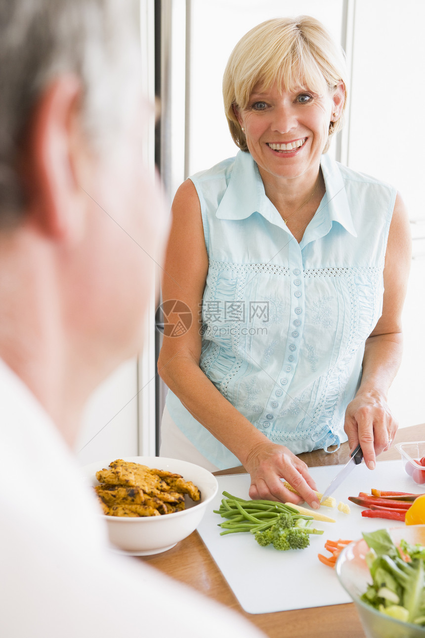 女人跟丈夫聊天 当她准备一顿饭时两个人团结男人妻子视图午餐吃饭时间享受晚餐图片