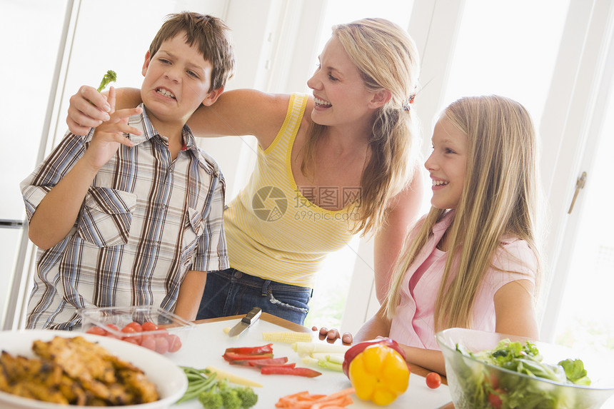 母亲与儿童一起准备一顿饭 共进晚餐家长孩子兄弟享受厌恶孩子们食物三个人蔬菜青春期图片