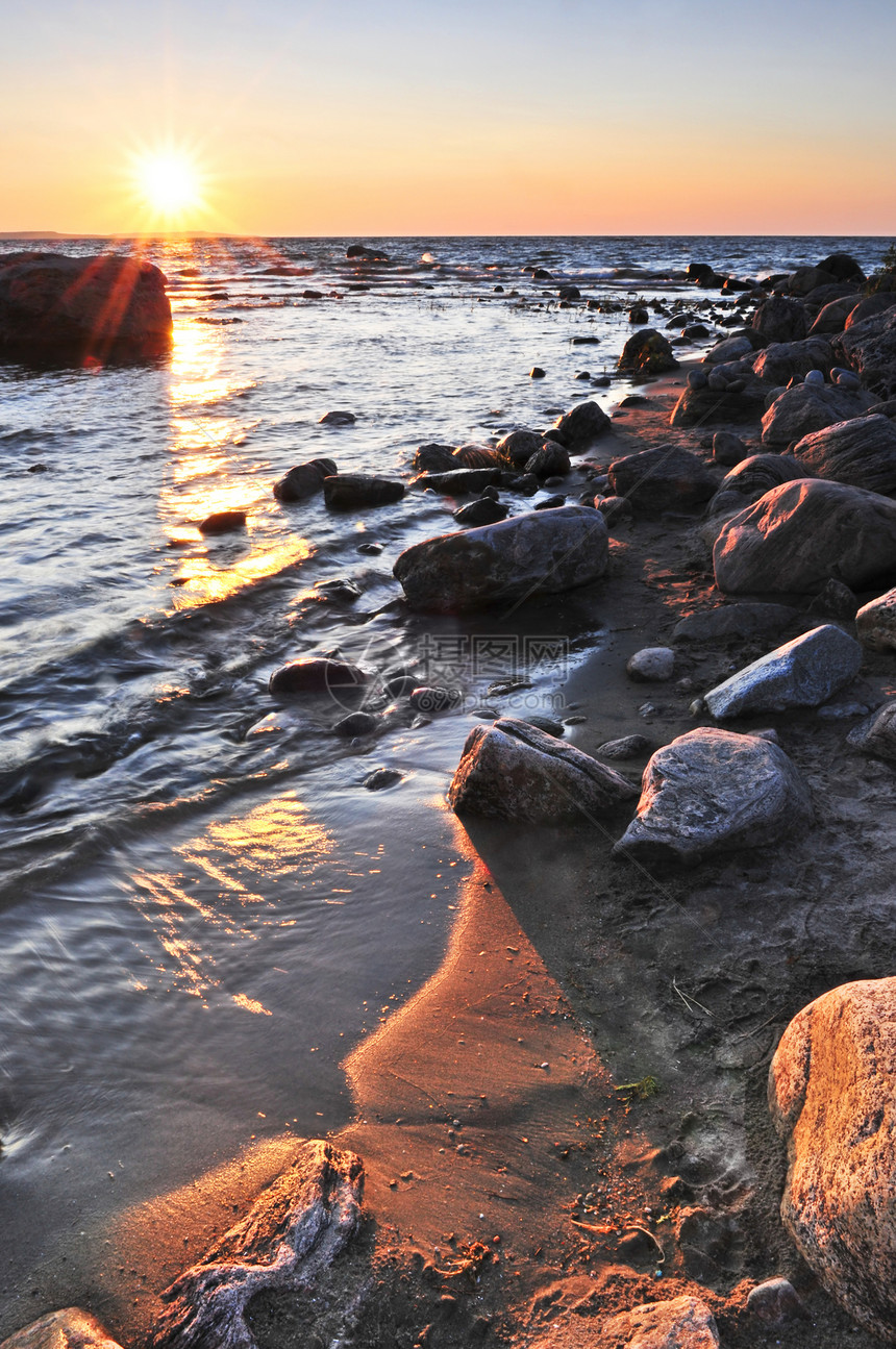 日落在水上公园反思地平线太阳石头岩石鹅卵石荒野海滩支撑图片